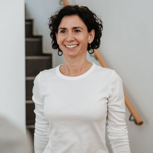 Claudia Potschigmann in Nahaufnahme vor einer Treppe als Female Empowerment Coach