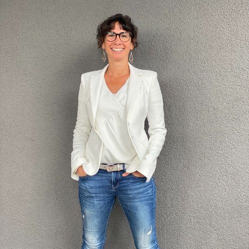 images-claudia-potschigmann-female-empowerment-coach-vor-einer-grauen-wand-im-weissen-blazer Claudia Potschigmann steht mit weißem Blazer, weißer Bluse und Jeans vor einer grauen Wand