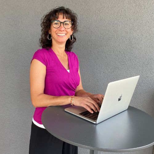 images-female-empowerment-coach-claudia-potschigmann-am-tisch-mit-MacBook Claudia Potschigmann steht an einem Stehtisch und schreibt am Macbook etwas zu ihrem Online Kurs