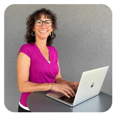 Claudia Potschigmann steht mit ihrem Macbook an einem Stehtisch, bei ihrem Selbstbewusstsein stärken Online Kurs